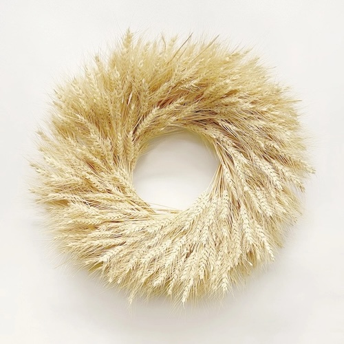 Photograph of a natural wheat wreath to demonstrate living room decor that goes with white farmhouse curtains