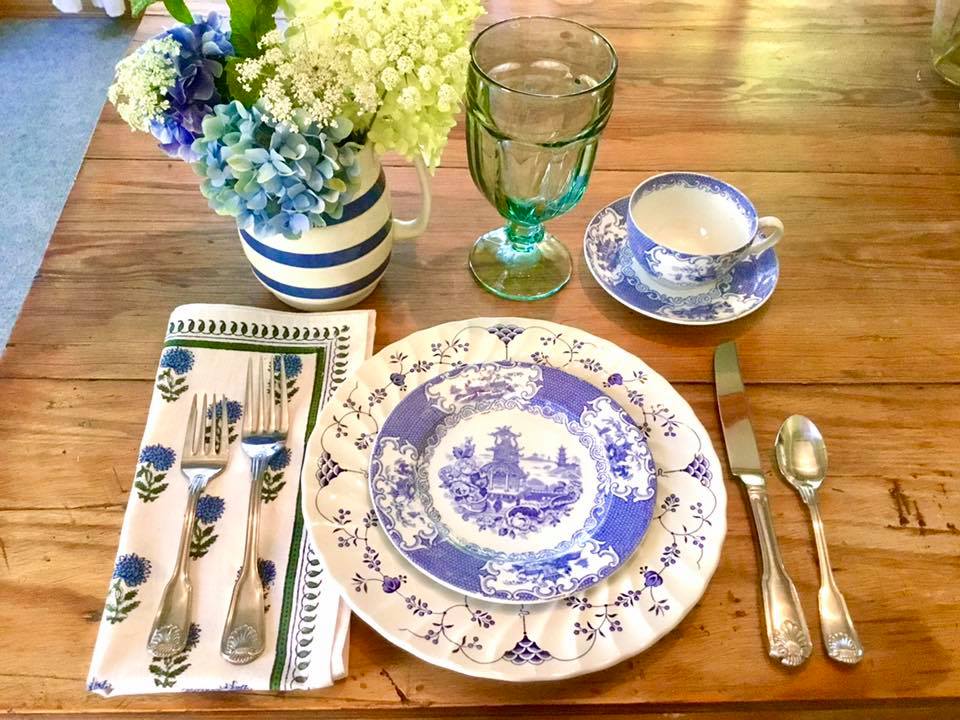 place setting with cottage style china, flowers, cloth napkins