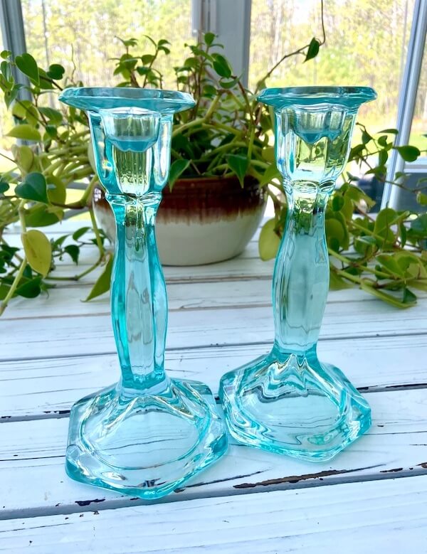 Photograph of two blue glass candlestick holders to demonstrate the idea of round table decor ideas