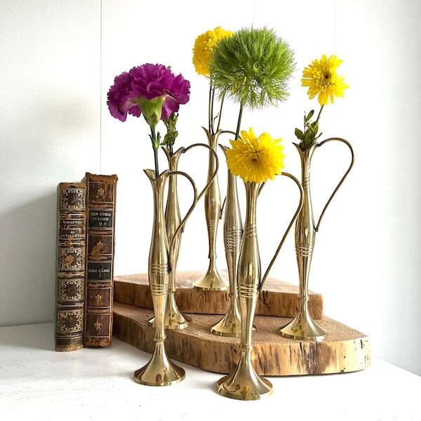 Six small brass vases to demonstrate sunflower decor ideas for the bedroom.