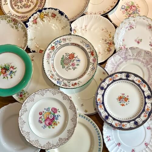 Mismatched vintage plates for French country decor using sunflower print tablecloth.