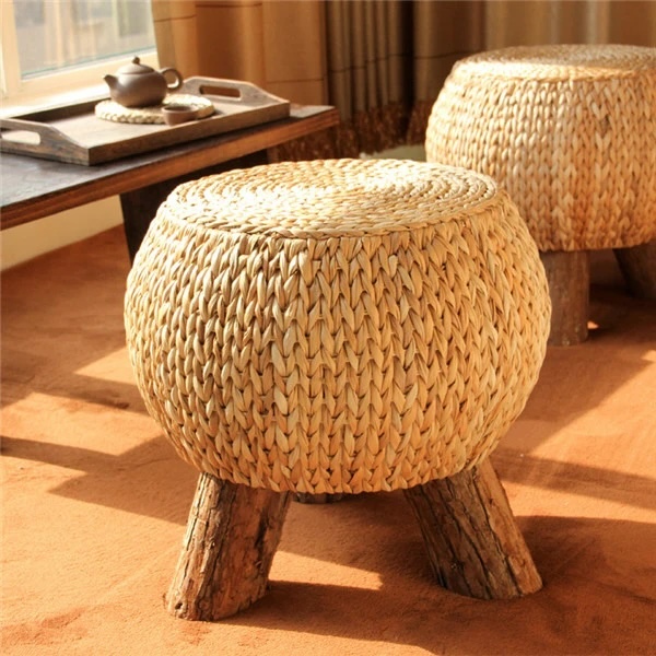 Woven rattan stool with three wooden legs to complement sunflower print curtains.