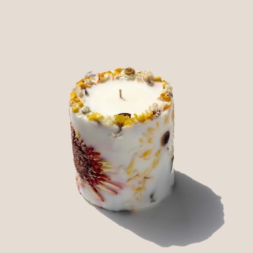 Photograph of candle with dried flowers to demonstrate fall floral decor